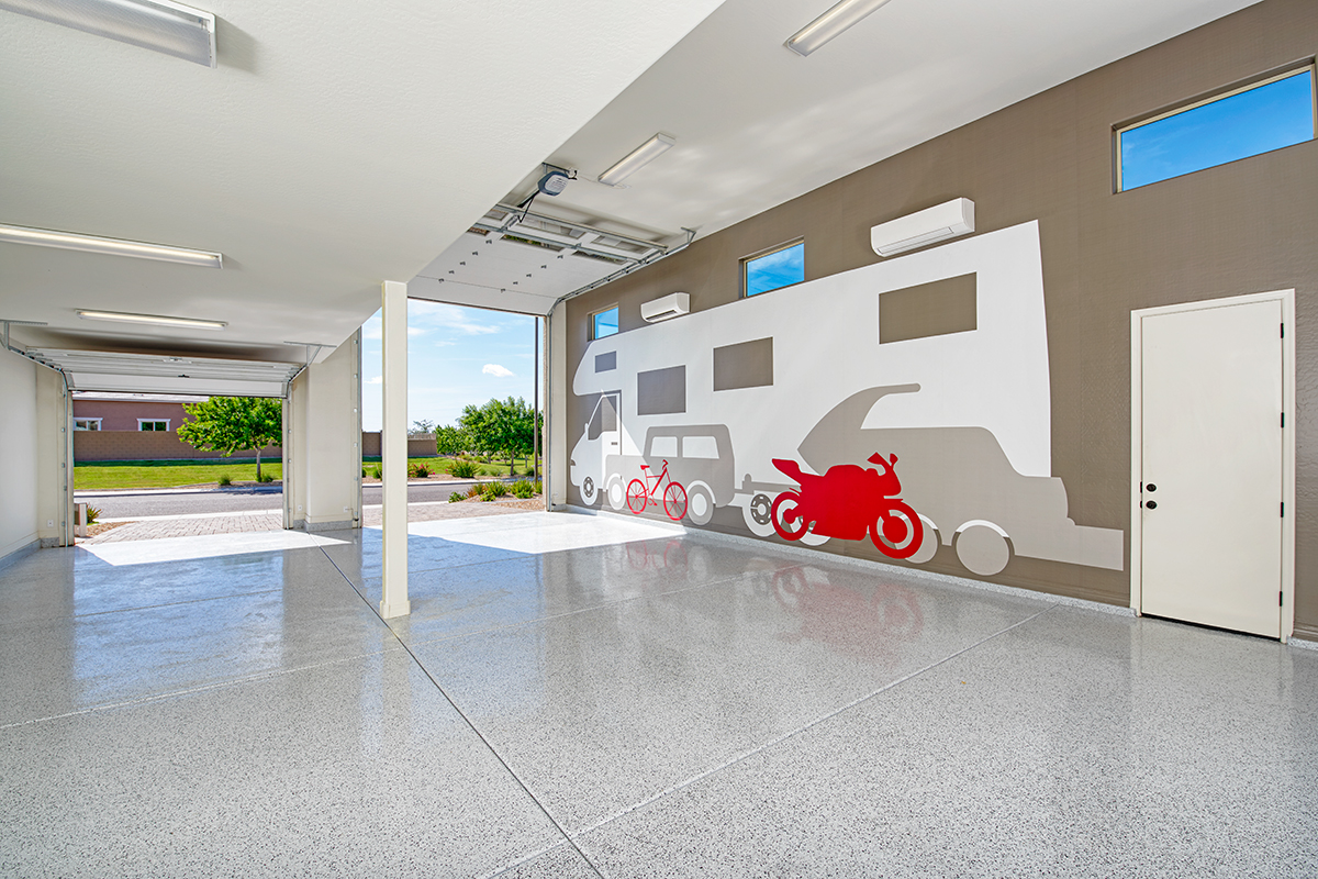 Ultra Garage interior with open regular garage door and Ultragarage door, and mural on wall of RV, truck hauling boat, motorcycle, and bike