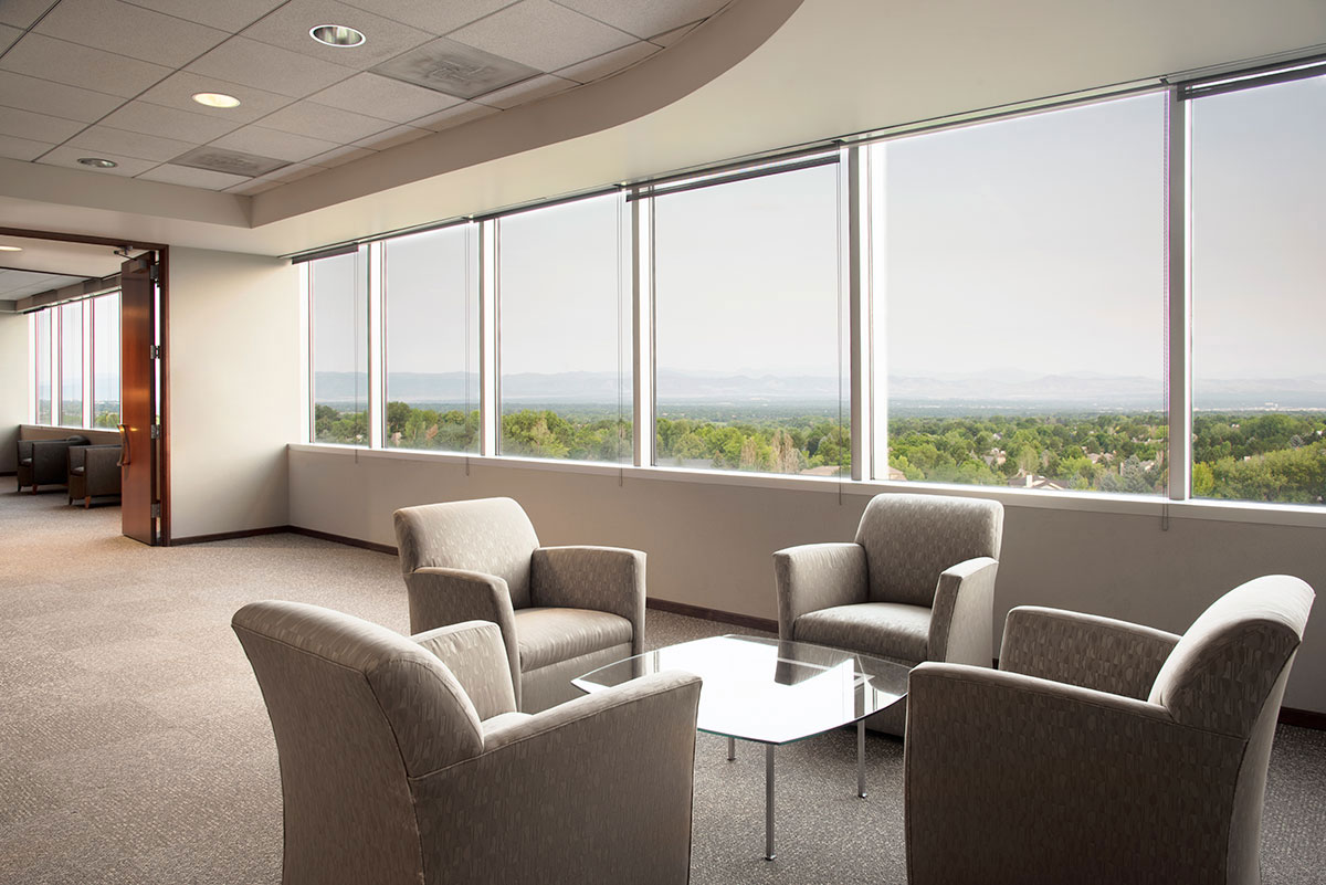 Lounge with chairs around small table and row of windows with moutain view