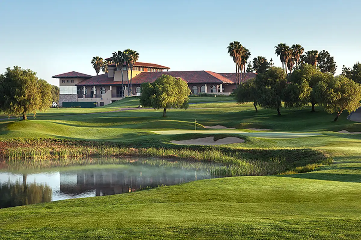 Golf course with sand pits, pond, and community center in the background