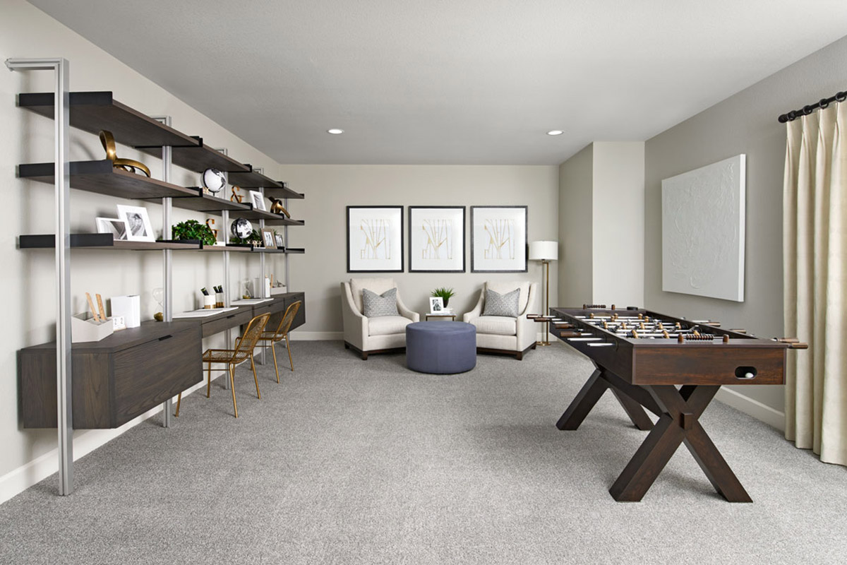 Basement area with large shelves and desk setup, two seats, and a foosball table