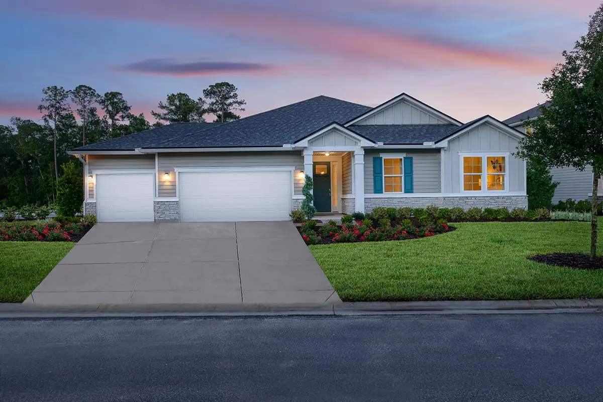 One-story home at dusk with three-car garage, front door, and windows to the right of the door