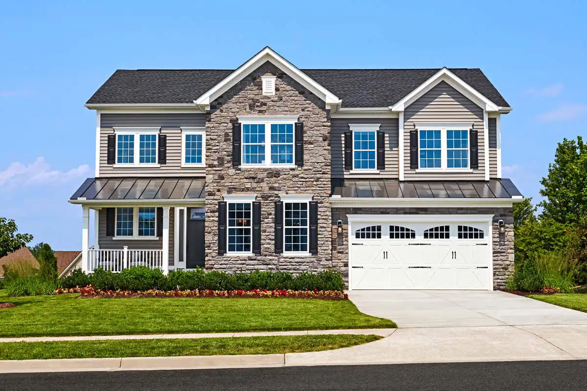 Two-story home with two-car garage, small front porch, and several windows