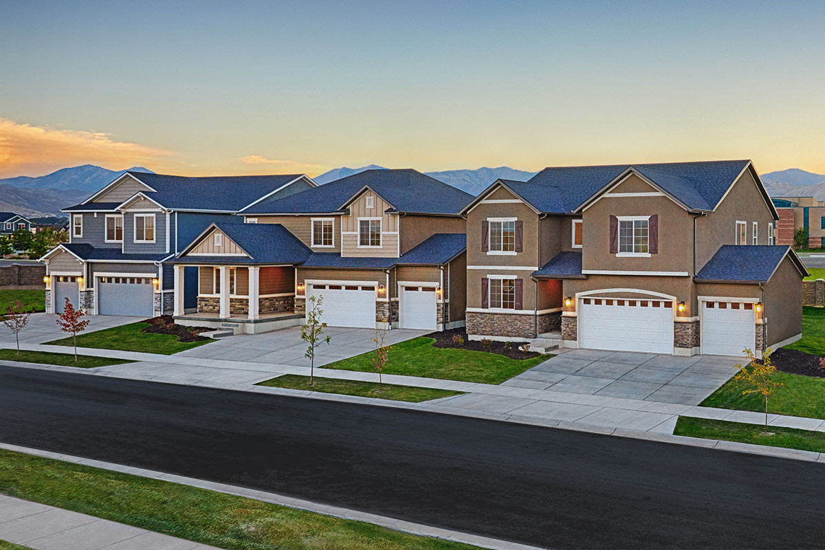 Three homes on a street, all two-stories and each with a three-car garage