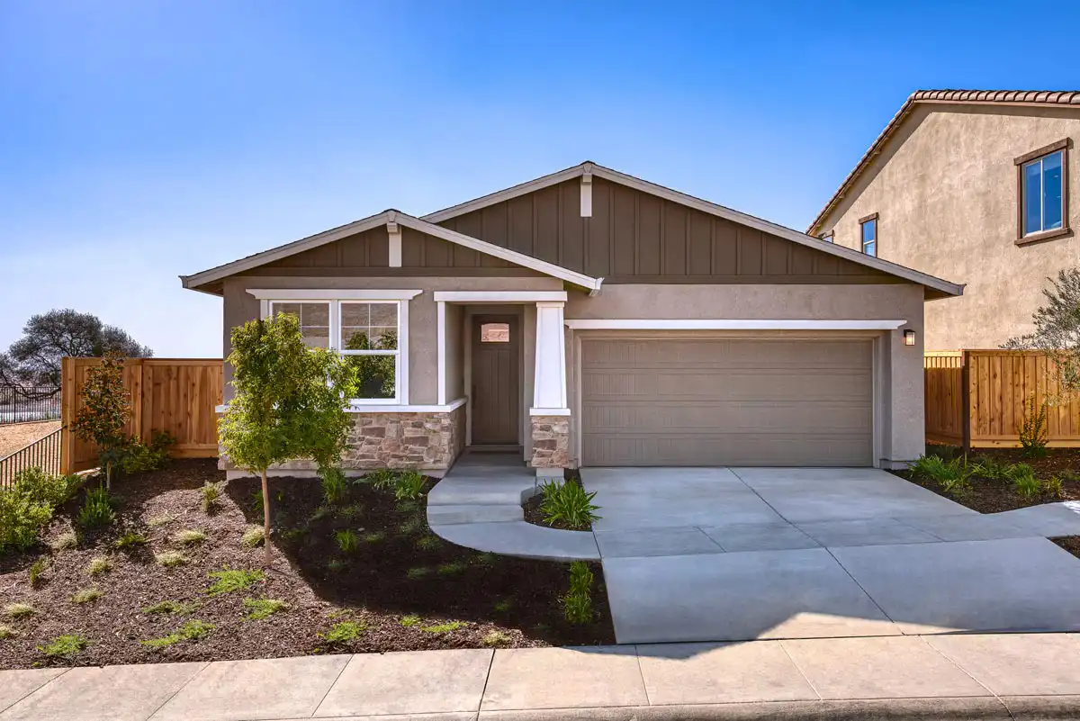 One-story home with two windows on the left, followed by a front door, and a two-car garage