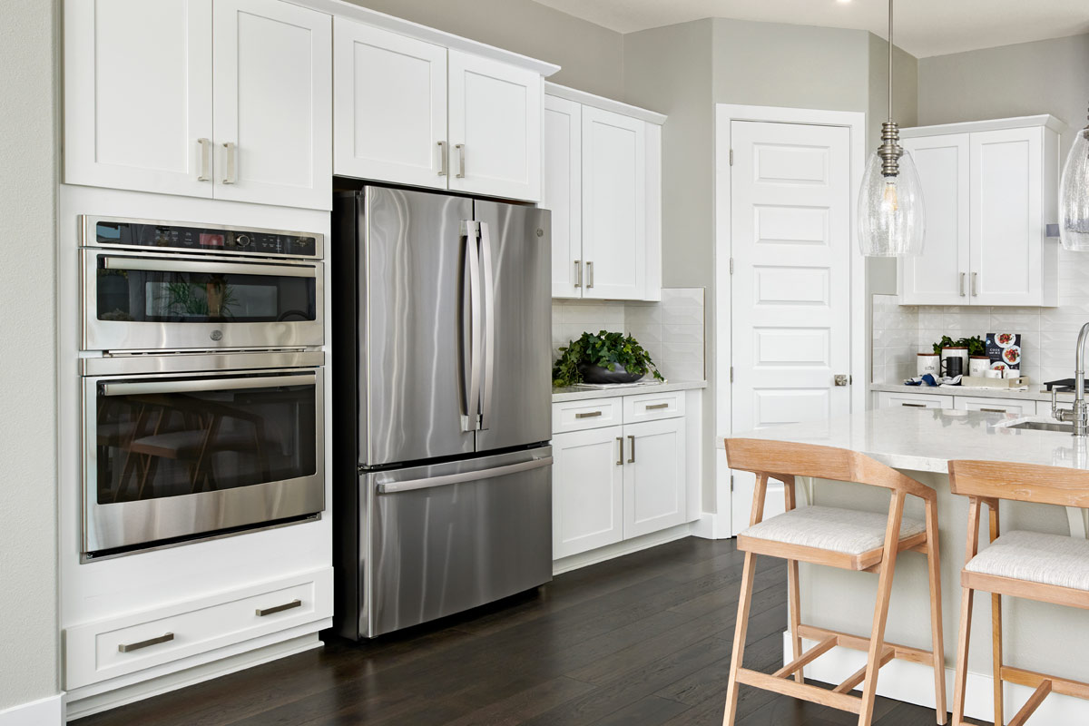 Kitchen with pantry door in corner, large refrigerator, double over, and large island