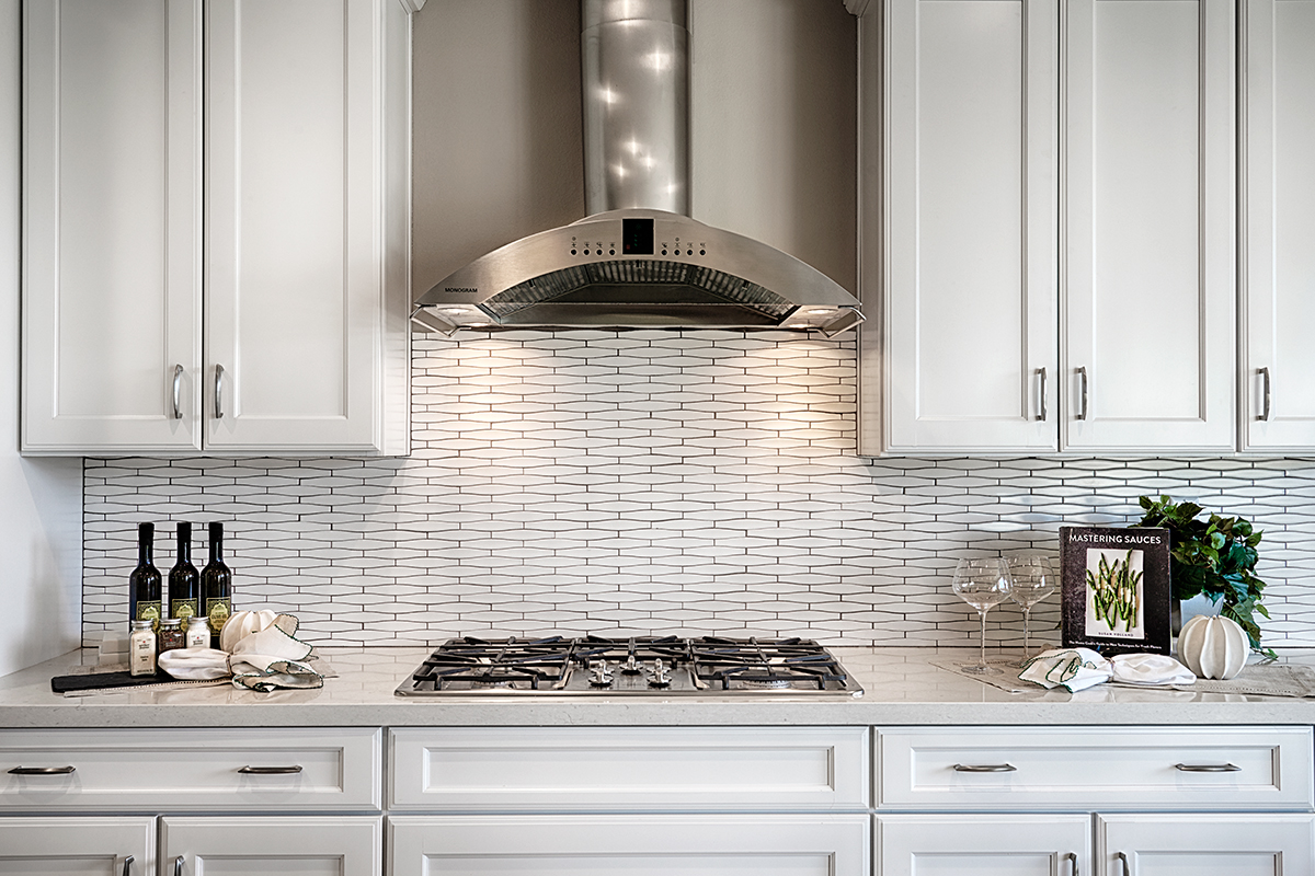 Cabinet with patterned backsplash and gas stove