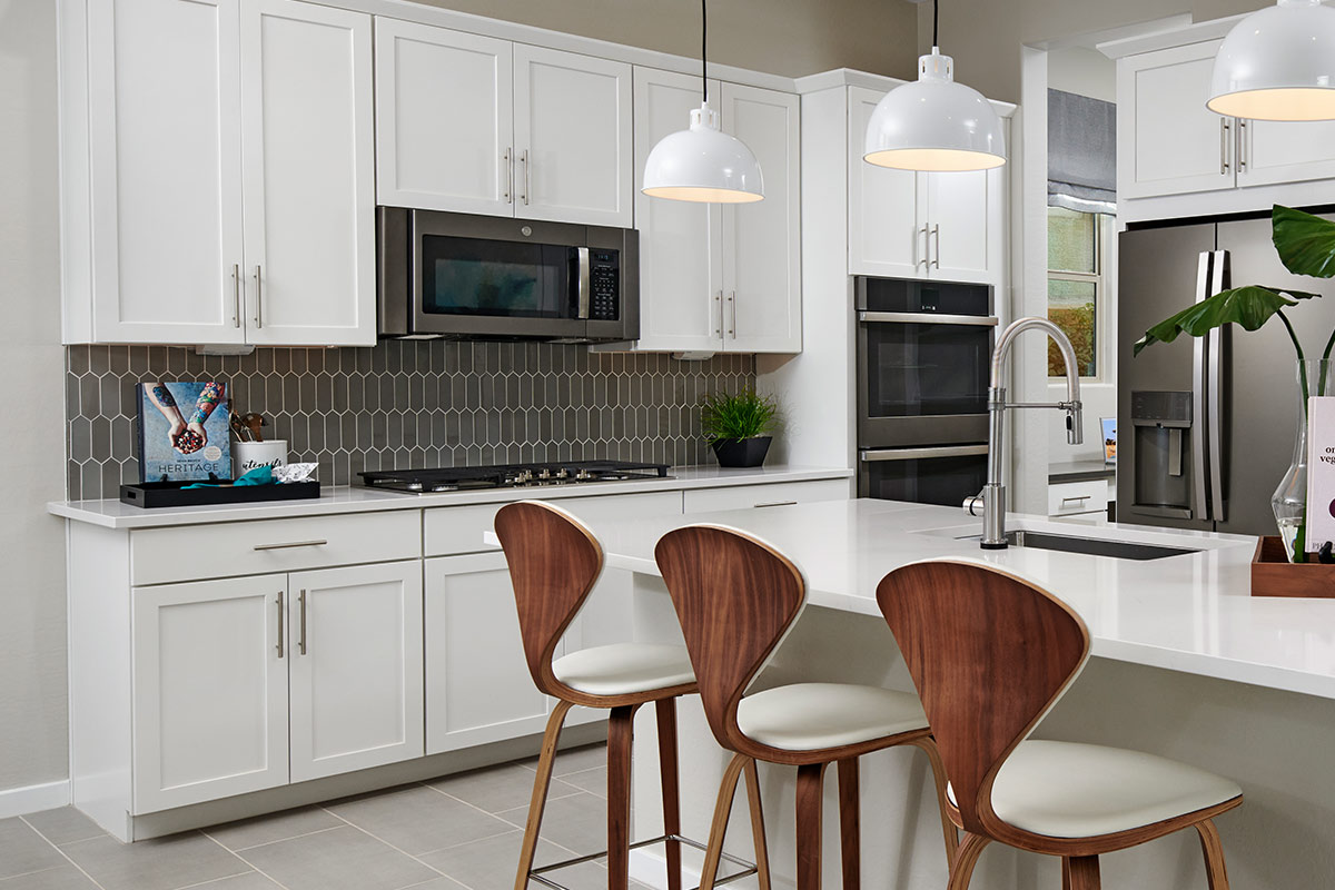 Kitchen with white cabinets, white island, and picket backsplash