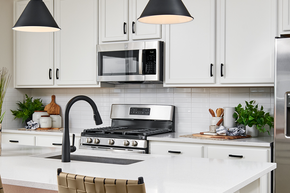 Kitchen with white cabinets, white countertop, black appliances and white paint 