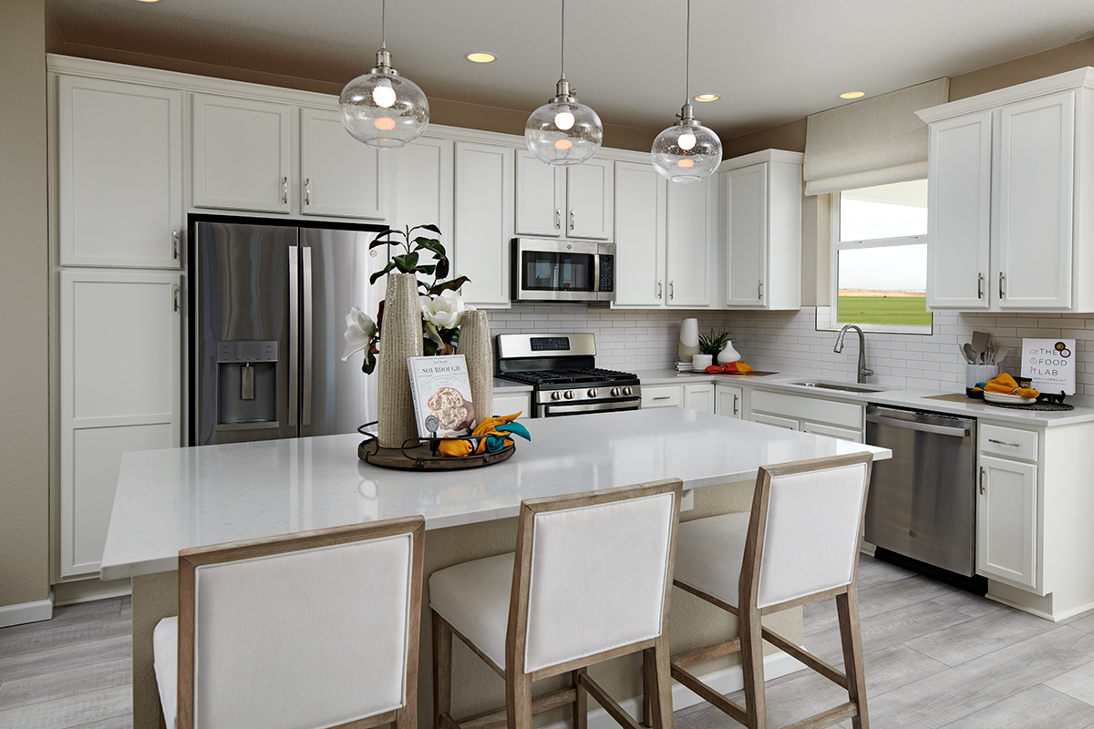 Kitchen with island with three chairs and brick-style backsplash