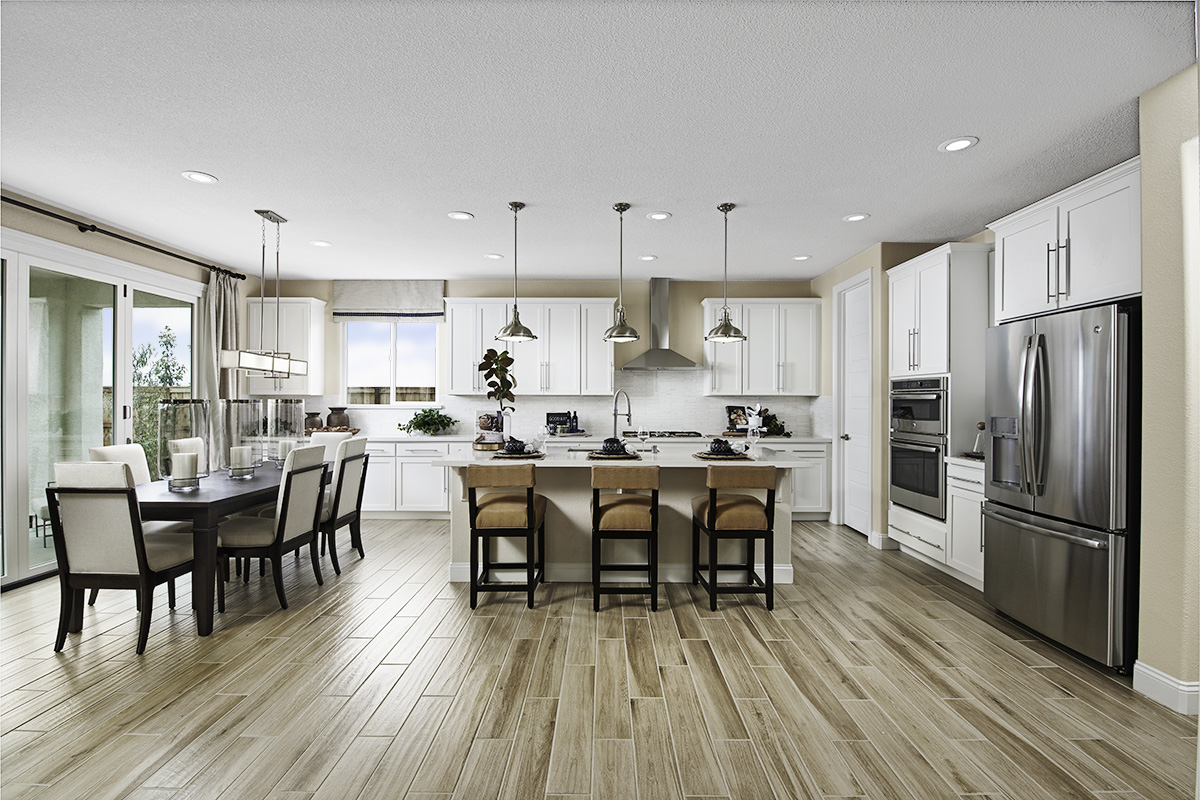 Large kitchen with wood floors island, pantry door, and dining table