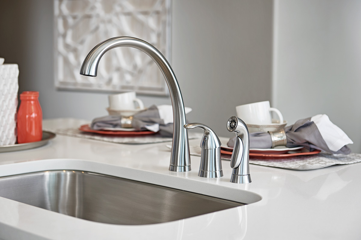 Kitchen sink with silver faucet, handle, and sprayer