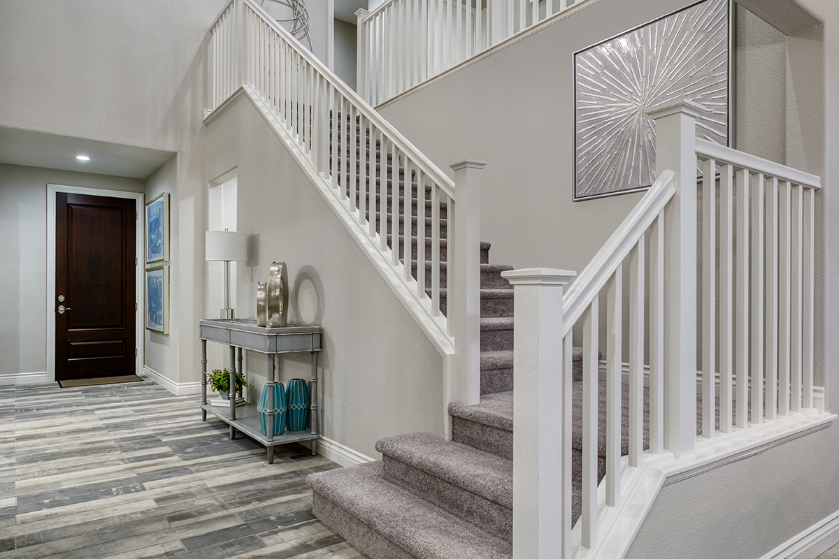 Front entry with carpeted stairwell to the second floor with wooden railings